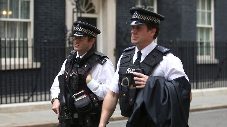 Schwer bewaffnete Polizisten patrouillieren in der Downing Street, wo sich der Sitz des Premiers befindet.