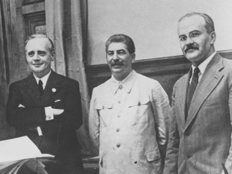 Josef Stalin zwischen den Außenministern Joachim von Ribbentrop und Wjatscheslaw Molotow. Links ist der deutsche Außenamts-Staatssekretär Friedrich Gaus.