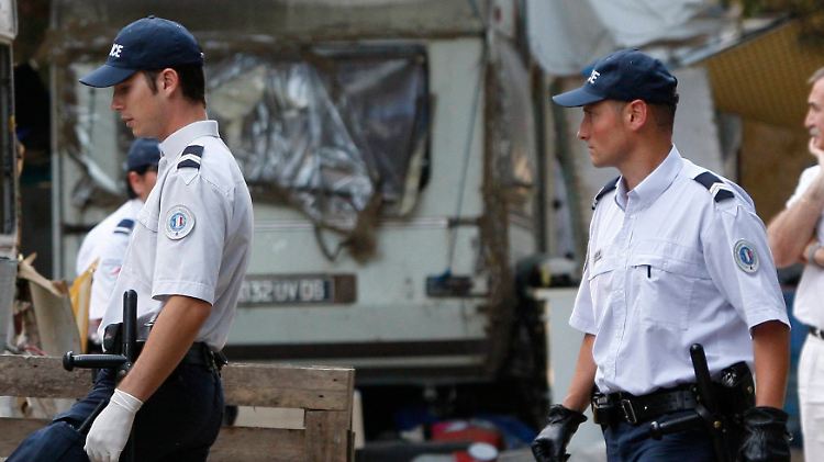 Polizisten durchsuchen ein Roma-Lager.
