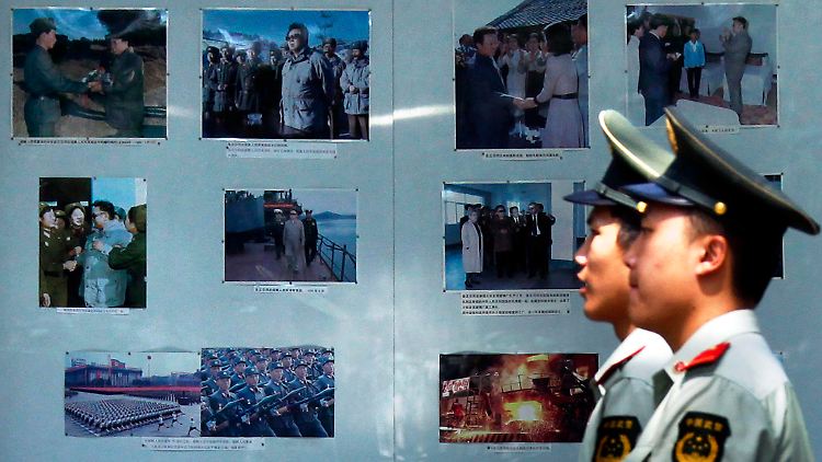 Chinesische Sicherheitskräfte patrouillieren an der nordkoreanischen Botschaft in Peking, wo Bilder Kim Jong Il und seinen Vater Kim Il Sung zeigen.