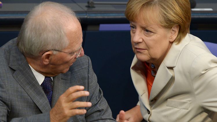 Schäuble im Gespräch mit der Kanzlerin während der Haushaltsdebatte im Bundestag.