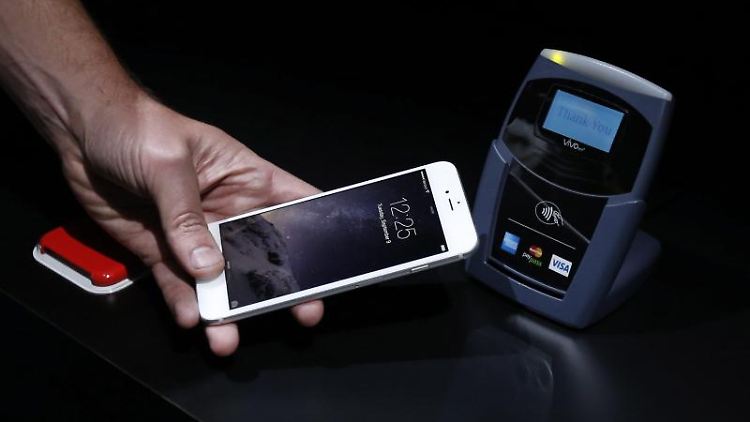 Bei Apple Pay wird iPhone an das Lesegerät gehalten und die Zahlung per Fingerabdruck auf dem iPhone-Sensor bestätigt.