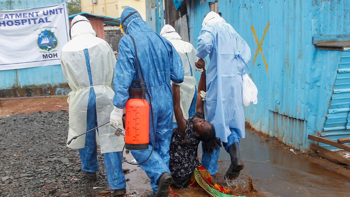 Liberianische Krankenschwestern schleppen eine Frau, die vermutlich an Ebola erkrankt ist, in ein Krankenhaus in Monrovia, 