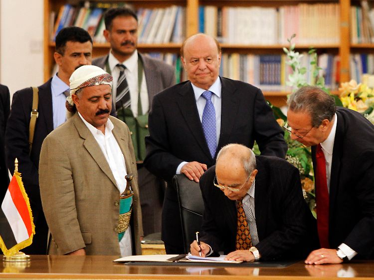 Präsidentenberater al-Iryani unterzeichnet im Beisein von Präsident Hadi (m.) und dem UN-Sondergesandten Benomar (r.) das Friedensabkommen mit den Huthi-Rebellen.