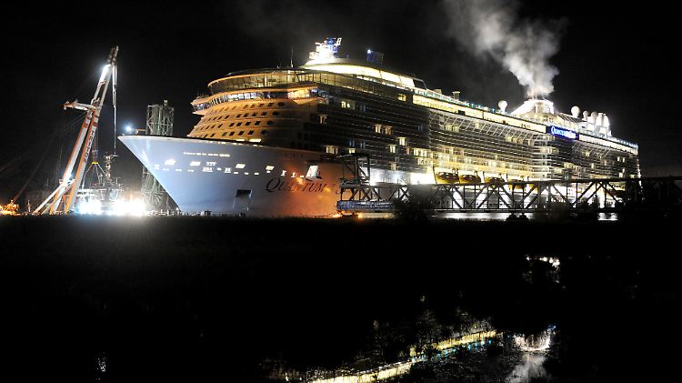 Der Kreuzfahrtschiff-Neubau der Meyer-Werft "Quantum of the Seas" passiert in der Nacht die teilweise demontierte Eisenbahnbrücke in Weener (Niedersachsen).