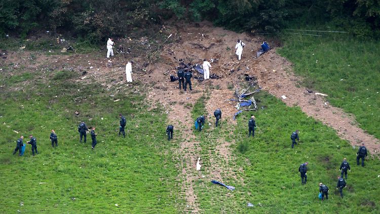 Brutale Narbe in der Landschaft: Polizisten und Ermittler der Bundesstelle für Flugunfalluntersuchung (BFU) untersuchen am Tag nach dem Absturz die Absturzstelle nahe Elpe bei Olsberg im Sauerland.