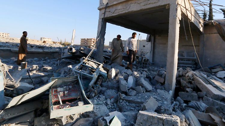 Menschen untersuchen Schäden an einer Fabrik in der Stadt Rakka, die von der US-geführten Allianz bombardiert wurde. Die Stadt ist Hauptstützpunkt des IS.