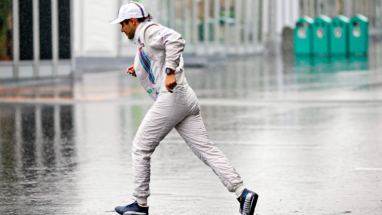 Jetzt aber schnell ins Trockene: Felipe Massa flüchtet vor den heftigen Regenfällen in Suzuka. Ein aufkommender Taifun könnte den Rennstart in Japan verhindern.