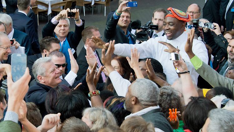 Gauck badet in der Menge und klatscht mit den afrikanischen Musikern ab. 