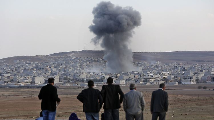 Aus sicherer Entfernung beobachten Anwohner die Explosionen in Kobane. 