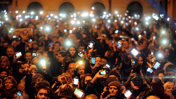 Mit hell erleuchteten Smartphones tun mehr als zehntausend Ungarn in Budapest ihre Meinung kund.