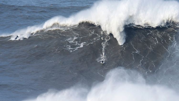 Surfer versuchen sich an der portugiesischen Atlantikküste auf Wellen von mehr als 20 Metern Höhe.