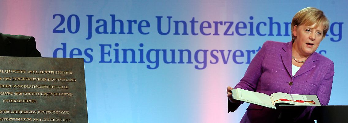 Merkel hält das historische Schriftstück in den Händen.