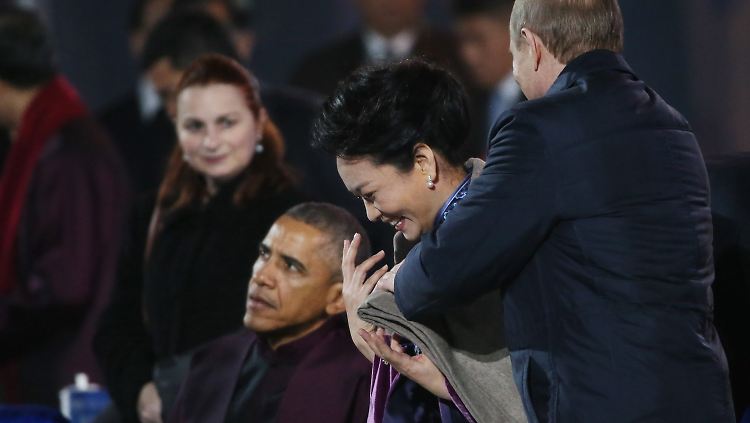Wladimir Putin  ist ganz Gentleman und legt Peng Liyuan eine Decke um die Schultern - eigentlich eine freundliche Geste. 