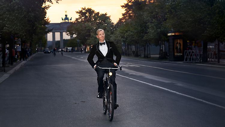 Entspanntes Radeln Unter den Linden, im Rücken das Brandenburger Tor, die Hände in den Hosentaschen: Max Raabe ganz lässig.