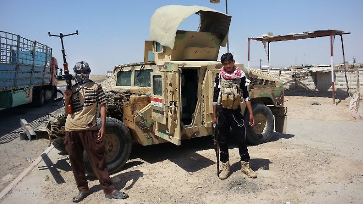 Islamistische Kämpfer mit einem erbeuteten irakischen Armeefahrzeug.