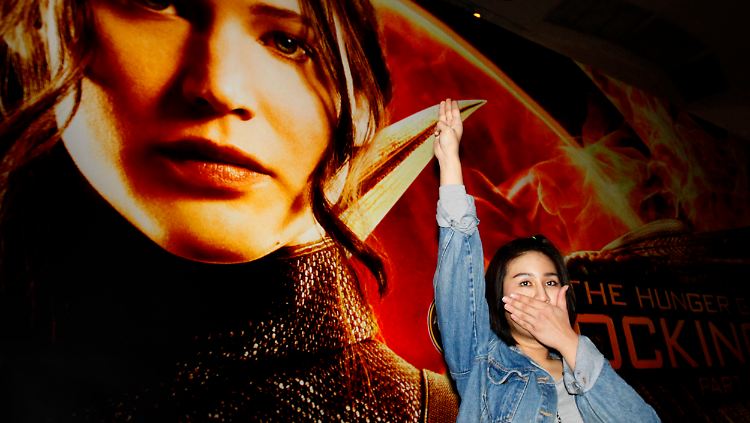 Junge Frau bei einer Filmpremiere in Bangkok: Das Drei-Finger-Zeichen wird im Verlauf der "Tribute"-Reihe zum Symbol des Widerstands gegen die Regierung. 