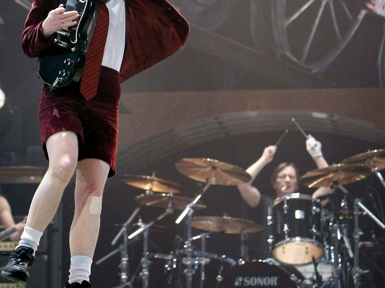 Der Mann am Schlagzeug: Während Frontmann Angus Young (l.) in bewährter Manier über die Bühne tobt, kümmert sich Phill Rudd um den AC/DC-Beat (Archivbild).