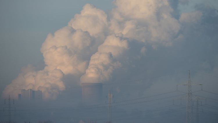 Aus dem Morgennebel ragen bei Pulheim (NRW) die Kühltürme des Braunkohlekraftwerkes Niederaußem.