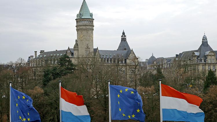 Luxemburgische und europäische Fahnen wehen vor dem Turm der Staatssparkasse in der Stadt Luxemburg.