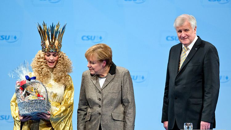 Was hat denn das Christkind im Körbchen? Merkel und Seehofer freuen sich über den Besuch des Christkinds.