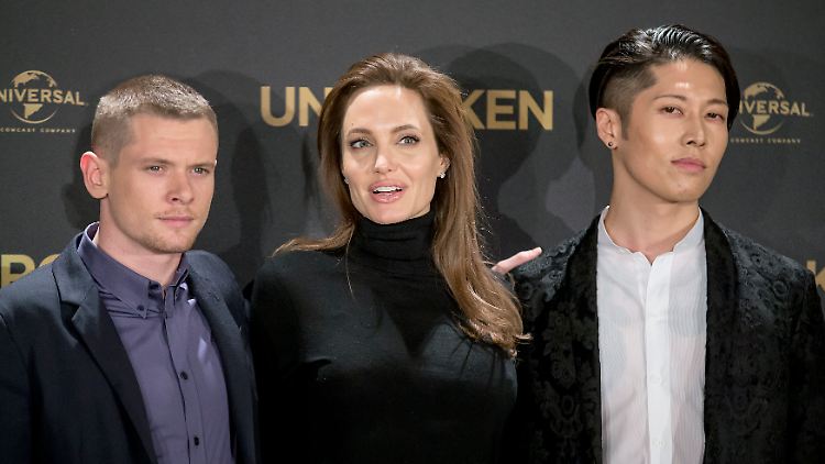 Ende November mit ihren Hauptdarstellern Jack O'Connell (l.) und Miyavi (r.) noch in Berlin, jetzt allein daheim im Bett: Angelina Jolie.