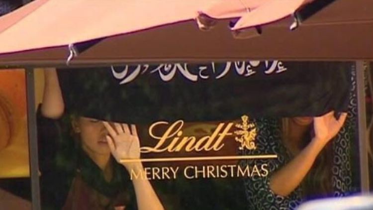 Die Geiseln mussten stundenlang Fahnen mit islamistischen Losungen ins Fenster des Cafés halten.