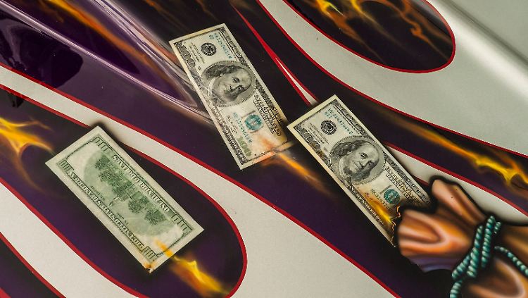 100-Dollar-Noten auf der Motorhaube eines Rennwagens.