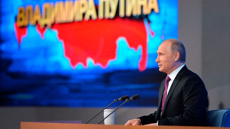 Putin vor einer Karte der Russischen Föderation. Links im Bild die Krim.