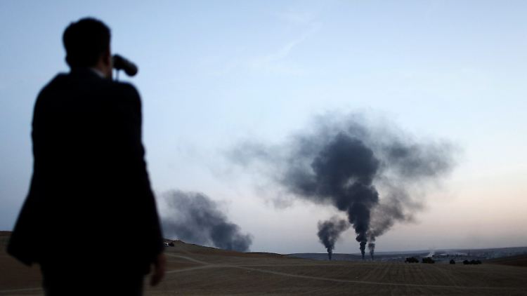 Ein Mann schaut aus der Ferne zu, wie Luftangriffe über Kobane geflogen werden.