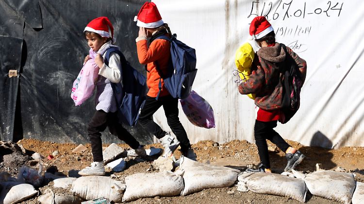 Syrische Flüchtlingskinder mit Weihnachtsgeschenken einer Hilfsorganisation im Libanon.
