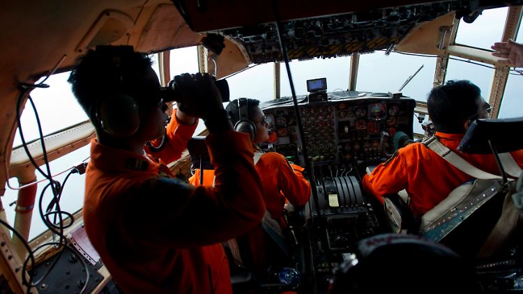 Per Schiff, mit Hubschraubern und mit Flugzeugen: Hier im Bild hält die Besatzung einer indonesischen C-130 "Hercules" Ausschau nach Trümmern des abgestürzten Air-Asia-Airbus'.