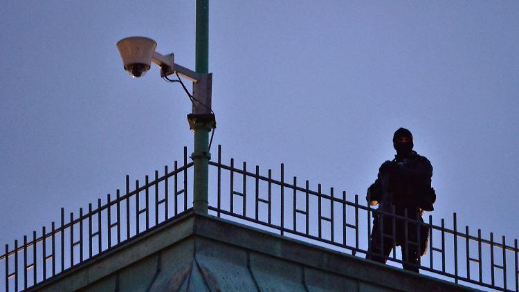 Ein seltenes Bild in Deutschland: Ein Scharfschütze der Polizei sicherte am Dienstagabend die Mahnwache am Brandenburger Tor. Sicherheitskontrollen gab es jedoch nicht.