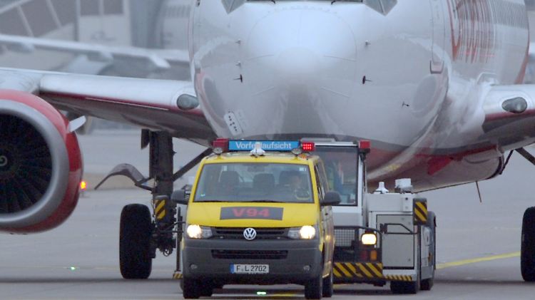  Ein sogenanntes "Follow-Me-Fahrzeug" der Vorfeldaufsicht geleitet eine Passagiermaschine auf das Rollfeld.