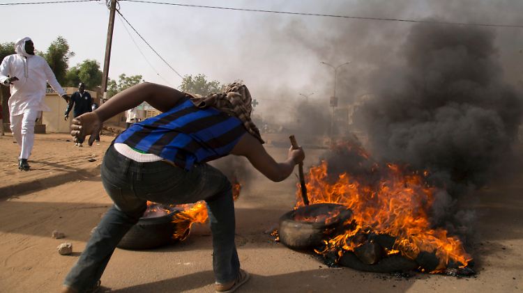 Ein Mann verbrennt bei Protesten gegen "Charlie Hebdo" in Niger einen Reifen.