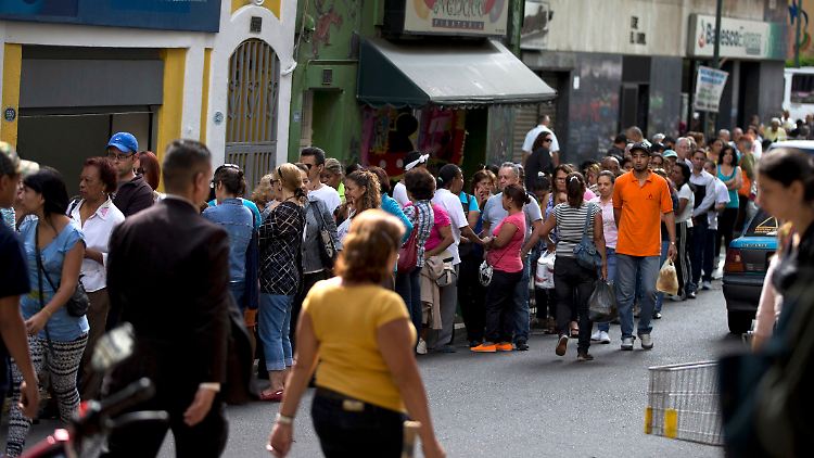 Kundenschlange vor einem Supermarkt in Caracas. Durchschnittlich verbringen die Venezolaner derzeit acht Stunden am Tag mit einkaufen.