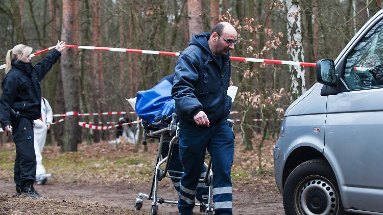 Mitarbeiter der Gerichtsmedizin transportieren die Leiche ab.