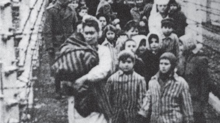 Eva (l) und Miriam (r) nach der Befreiung Ende Januar 1945. Für die Aufnahme zogen sie einen gestreiften Anzug an - normalerweise durften Zwillinge auch andere Kleidung tragen.