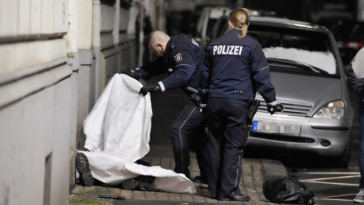 Geschockt am Tatort: Beamte der Wuppertaler Polizei decken die Leiche des Schützen mit Tüchern ab.