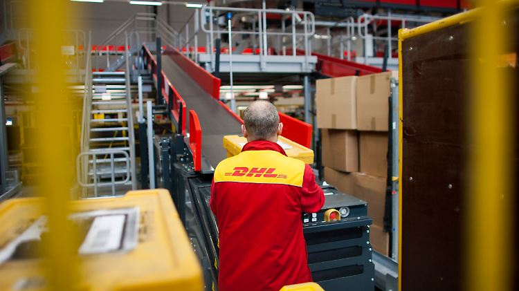 Paketzusteller in einem DHL-Verteilcenter. Sie will die Post zu neuen Konditionen beschäftigen.