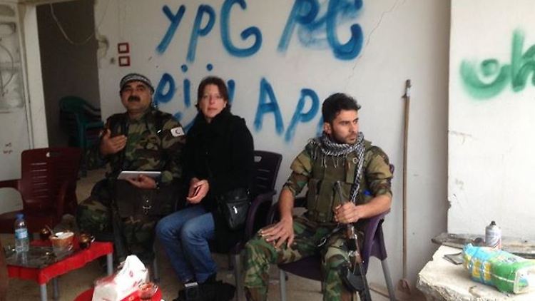 Frederike Geerdink sitzt zwischen zwei Peschmerga-Kämpfern in Kobane.