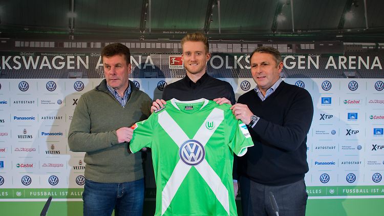 Neuzugang André Schürrle steht bei seiner Vorstellung beim Fußball-Bundesligisten VfL Wolfsburg mit Trainer Dieter Hecking (l) und Manager Klaus Allofs in der Volkswagen Arena in Wolfsburg.
