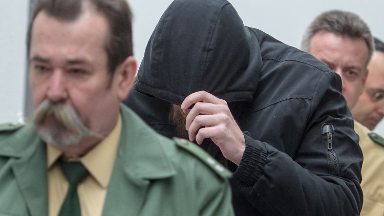 Der 27 Jahre alte Angeklagte versteckte sich zu Prozessbeginn unter einer schwarzen Kapuze.