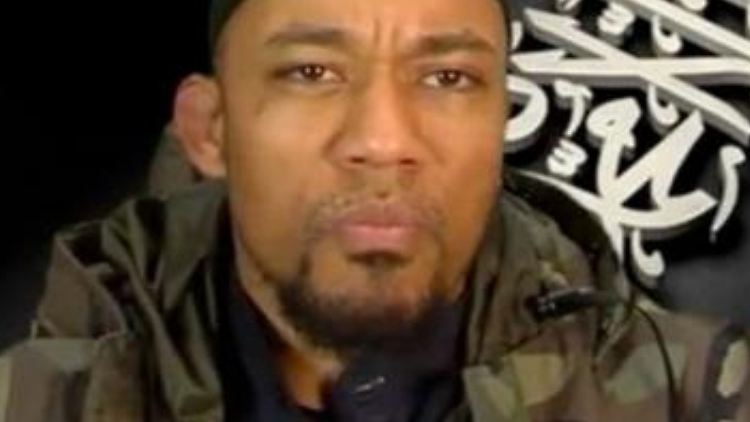 Denis Cuspert zeigt sich vor der Flagge der Islamisten.