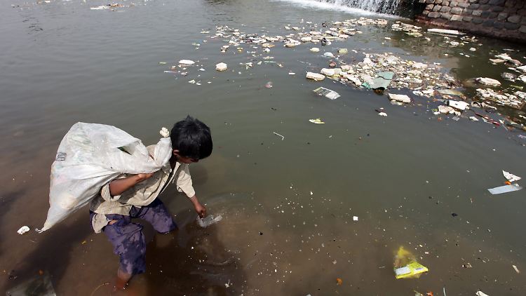 Ein indisches Kind sucht im verschmutzten Tawi-Fluss nördlich der Stadt Jammu nach verwertbaren Dingen.