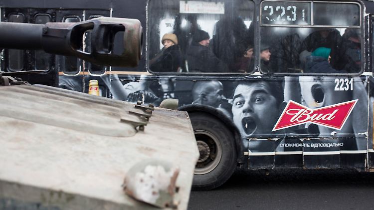 Straßenszene in Donezk: Ein Stadtbus passiert eine Kolonne von Panzerhaubitzen der prorussischen Separatisten.