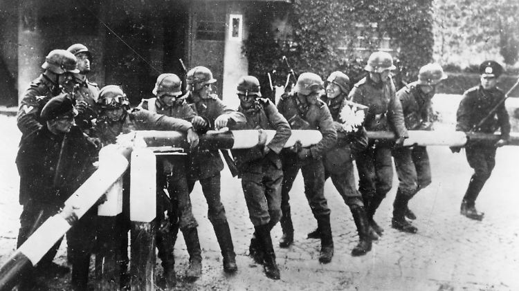 1. September 1939: Soldaten der deutschen Wehrmacht reißen an der deutsch-polnischen Grenze einen Schlagbaum nieder.