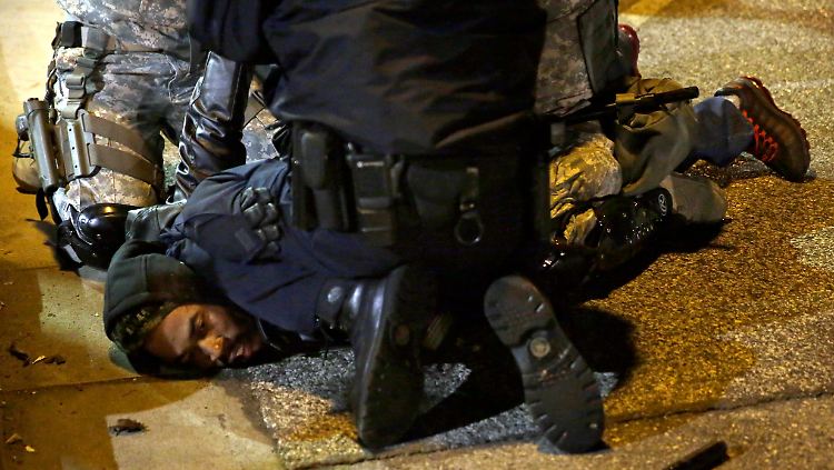 Polizisten verhaften einen schwarzen Demonstranten während der Unruhen in Ferguson.
