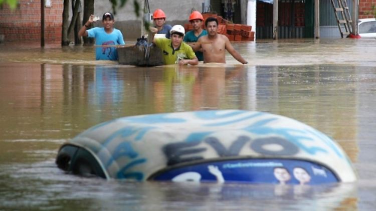 Diese Männer waten über die vom Fluss Acre überschwemmte Straße an der brasilianisch-bolivianischen Grenze.  