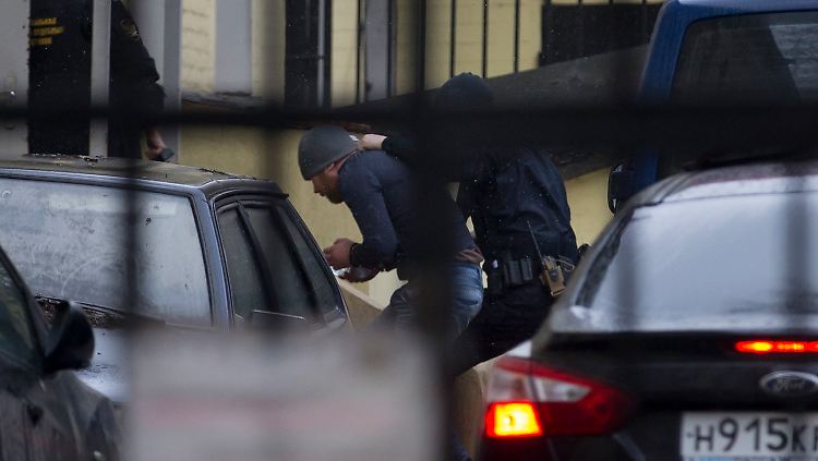 Ein Verdächtiger wird von einem Polizisten ins Moskauer Gerichtsgebäude geführt. 